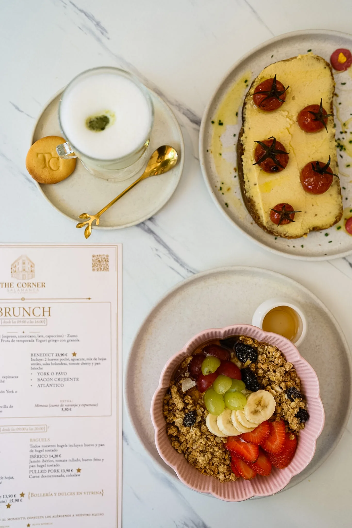 The Corner Salamanca menu beside brunch dishes, coffee and a seasonal fruit bowl.
